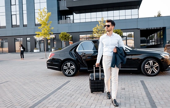 Businessman with luggage using car rental