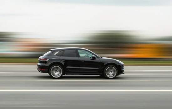 Black SUV speeding on highway for car rental 